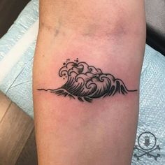 a small wave tattoo on the leg