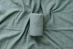 an unmade bed with blue sheets and pillows