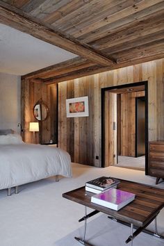 a bedroom with wood paneled walls and white carpeting, along with a large bed