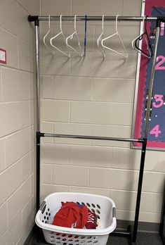 a white laundry basket sitting on top of a black shelf