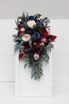 a bouquet of flowers sitting on top of a white frame