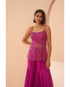 Candy Pink Sharara Set - Parul Gandhi Embrace elegance in this tonal pink sharara set, showcasing a peplum top adorned with a cutwork neckline. The harmonious blend of shades and the intricate detailing add a touch of sophistication to this ensemble, making it a perfect choice for those seeking a graceful and contemporary ethnic look. Included in Purchase: Sharara Top, Pant & Dupatta Product Specification Color: Hot Pink Fabric: Mesh and Organza Neckline: Square Neckline Occasion: Bridal, Engage Bollywood Style Pink Sleeveless Palazzo Set, Pink Sleeveless Bollywood Palazzo Set, Pink Bollywood Style Sleeveless Palazzo Set, Pink Sleeveless Palazzo Set For Party, Sleeveless Pink Palazzo Set For Party, Pink Sharara With Resham Embroidery, Bollywood Style Pink Peplum Sets, Pink Peplum Bollywood Sets, Pink Peplum Sharara For Festive Occasions