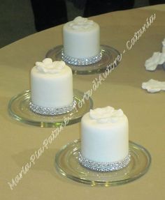 three small white cakes sitting on top of a table