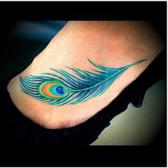 a peacock feather tattoo on the foot