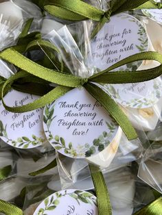 wedding favors wrapped in cellophane and tied with green ribbon, sitting on top of each other