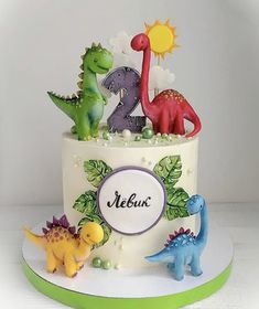 a two tiered birthday cake decorated with dinosaur figurines and the number twenty