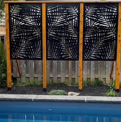 a pool with a wooden fence next to it and a blue swimming pool in the foreground