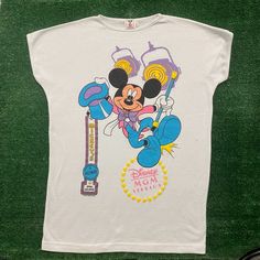 Vintage 80s Disney Mgm Studios Mickey Single Stitch T-Shirt Size: L (Osfa) Chest: 21" Length: 30" White Short Sleeve Crewneck T-Shirt By Disney Wear With Walt Disney World Mgm Studios Broadway Style Mickey Mouse Graphic. Made In Usa. Single Stitch. Boxy Fit. Essential 1980s Cartoon Tee. Free Shipping On Bundles. Feel Free To Send An Offer. Preowned Clothing May Have Flaws. Please View All Pictures And Ask Any Questions Prior To Purchase. All Sales Are Final. Returns Not Accepted. Check Out Our Other Listings To Bundle And Save! We Have Thousands Of Vintage Graphic Tees In All Sizes And Styles. Follow Us To Catch New Drops - Steals Posted Daily! Thanks For Shopping Sustainably! Tags: G 80s Disney, Disney Trip Outfits, Disney Wear, Mgm Studios, Vintage Graphic Tees, Skater Punk, Trip Outfits, Disney Men, Graphic Tees Vintage