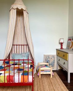 a child's bedroom with a canopy bed and dresser