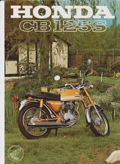 an orange motorcycle parked in the grass near a house and trees with white lettering that reads honda cbi255s