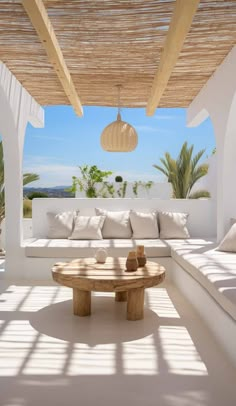 a living room with white couches and wooden tables on top of it's floor