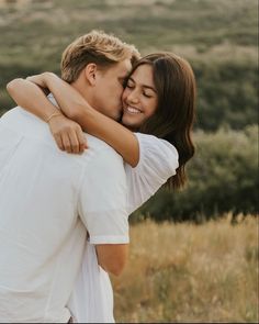 a man and woman embracing each other in a field