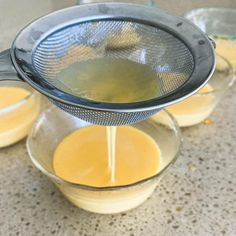 three glass bowls filled with liquid on top of a counter