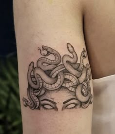 a woman's arm with a tattoo on it that looks like a snake wrapped around her head