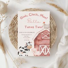 a pink book sitting on top of a wicker basket next to a white plate