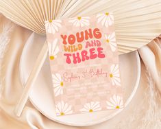 a pink and yellow birthday card with the words young wild and three printed on it