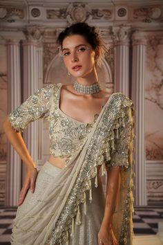 Step into glamour with this exquisite gray sari, crafted from luxurious sequined fabric. The heavy skirt provides a stunning foundation, while the draped pallu is fully embroidered, featuring beautiful long tassels that add a playful touch. The padded blouse ensures a flattering fit, making this ensemble perfect for grand occasions where elegance and sophistication are essential. Embrace the allure of this captivating outfit, designed to make a lasting impression. Sequence Fabric, Skirt Saree, Sequence Skirt, Sequined Fabric, Sari Skirt, Sequined Skirt, Tuxedo Accessories, Beaded Work, Grey Saree