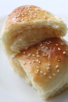 two pieces of bread sitting on top of a white plate with sesame seed sprinkles