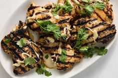 grilled chicken with cilantro sauce on a white plate