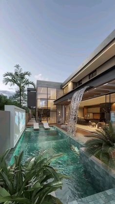 a house with a pool and waterfall in the front yard, surrounded by palm trees