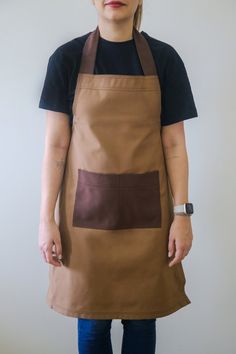 a woman wearing an apron with two different colors on the front and one is brown