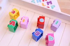 several colorful wooden blocks with letters and numbers on them sitting next to a play tray