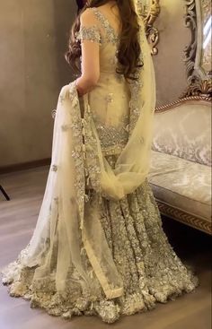 a woman in a wedding dress standing near a mirror