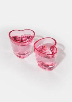 two heart shaped glasses sitting next to each other