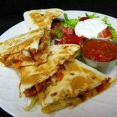 three quesadillas on a plate with salsa and lettuce