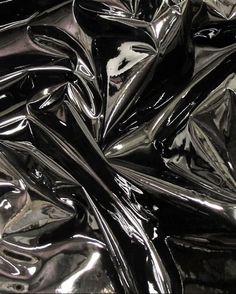 shiny black material is shown in close up view, as if it were plastic or metal