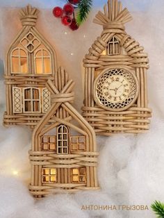 three small wooden houses with windows and a clock on the front one is made out of wicker