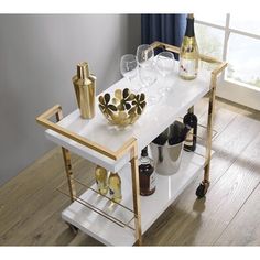 Host guests with panaches and style with the serving cart. This bar cart is perfect for serving guests, hosting parties, or just having a place to store an attractive cocktail setup. Two-tiers provide plenty of room for beverage prep and glassware storage. Dual bottle caddies keep wine bottles safe from tipping while rolling smoothly to where the action is. The ultra-luxe and modern gold-plate frame adds a sophisticated design element, and the high-gloss laminate cleans up with just a wipe. Lock New Orleans Apartment, Hosting Parties, Gold Bar Cart, Floating Bed Frame, Velvet Upholstered Bed, Brown Chair, Glassware Storage, Serving Cart, White Laminate