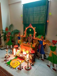 a group of people standing around a small shrine with candles and decorations on the floor