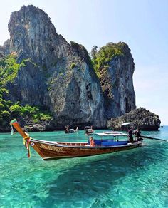 two boats in the water near some rocks