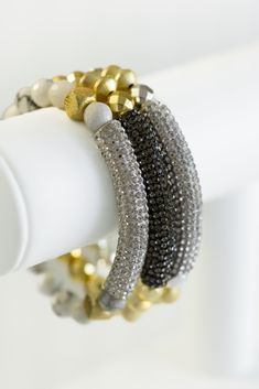 Add some wrist candy to your look with this stunning stretch bracelet featuring beautifully crafted stone beads and a dazzling crystal rhinestone bar. In a mesmerizing white, silver, and gold combination, it's the perfect accessory for any occasion! Also comes in gold and silver! Elegant Black Bangle Stretch Bracelet, Elegant Black Crystal Bracelet With Faceted Beads, Elegant Black Crystal Bangle Bracelet, Luxury Black Hand-strung Beaded Bracelets, Gold Cubic Zirconia Multi-stone Bracelets, Black Bracelet, Wrist Candy, White Bracelets, Black Bracelets