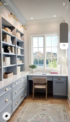 a home office with built - in shelving units and a rug on the floor