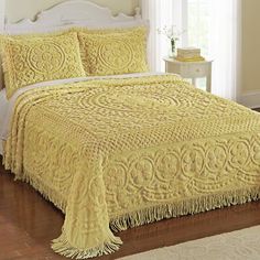 a bed with yellow bedspread and pillows