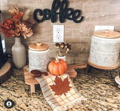 a kitchen counter topped with coffee canisters and fall decorations