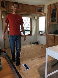 a man standing in the middle of a room that is being remodeled with wood flooring