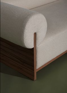 a close up view of a bed with wood and white fabric on the headboard