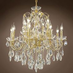 a gold chandelier with crystal drops hanging from it's center and sides