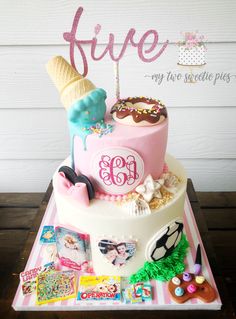 a birthday cake with an ice cream cone, sunglasses and other items on it that says five my two sweetie picks