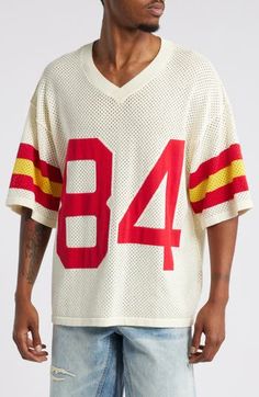 This rah-rah cotton-mesh jersey is designed in a slouchy oversized fit with dropped shoulders and features appliquéd varsity lettering and numerals. 27" length (size Medium) V-neck Elbow-length sleeves 100% cotton Machine wash, dry flat Imported Oversized Varsity Tops For Sports, Retro Oversized Tops For Game Day, Oversized Retro Top For Game Day, Casual Cotton Jersey For Streetwear, Casual Cotton Streetwear Jersey, Casual Cotton Jersey For Game Day, Retro Red Oversized Top, Oversized Retro Red Top, Cotton Drop Shoulder Sports Top