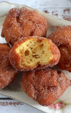 some sugared doughnuts are on a plate