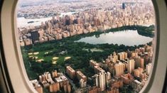 an aerial view of a city and lake from the window of an airplane in flight