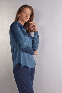 Long sleeve shirt in light stretch silk with collar and buttons up the middle. Back yoke with pleat for a draped, loose fit. Buttoned cuffs and rounded hem. Elegant Shirt With Roll-up Sleeves And Spread Collar, Elegant Solid Blouse With Roll-up Sleeves, Elegant Office Tops With Roll-up Sleeves, Elegant Office Top With Roll-up Sleeves, Elegant Roll-up Sleeves Tops For Office, Elegant Blue Tops With Button Cuffs, Elegant Blue Top With Button Cuffs, Elegant Shirt With Roll-up Sleeves For Work, Elegant Workwear Shirt With Roll-up Sleeves