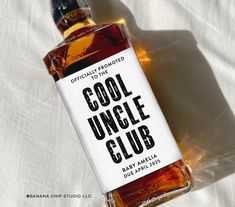 a bottle of cool uncle club sitting on top of a white sheet with the label