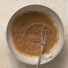 a white bowl filled with spices and whisk on top of a countertop