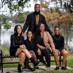 a family poses for a photo on a park bench