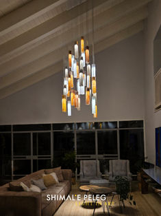 a living room filled with furniture and a chandelier hanging over the top of it